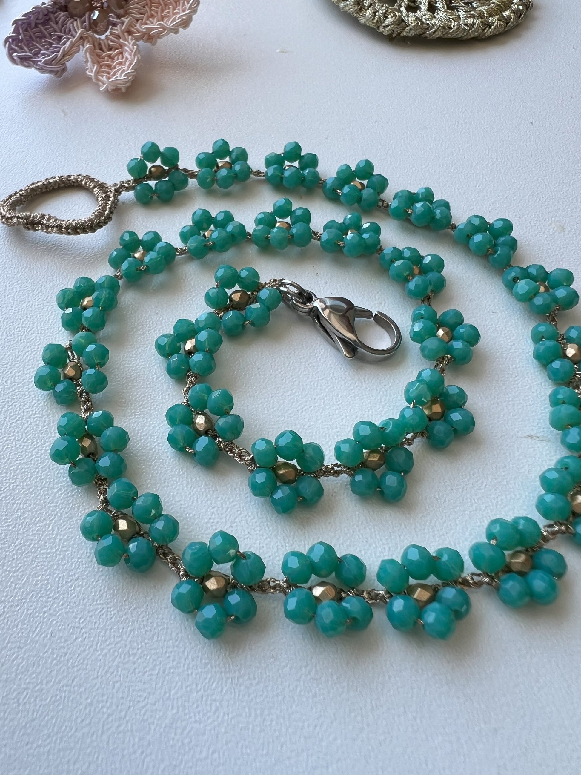 Collana Verde Incanto: miniature floreali in verde smeraldo creano un girocollo delicato e raffinato, perfetto per ogni outfit.