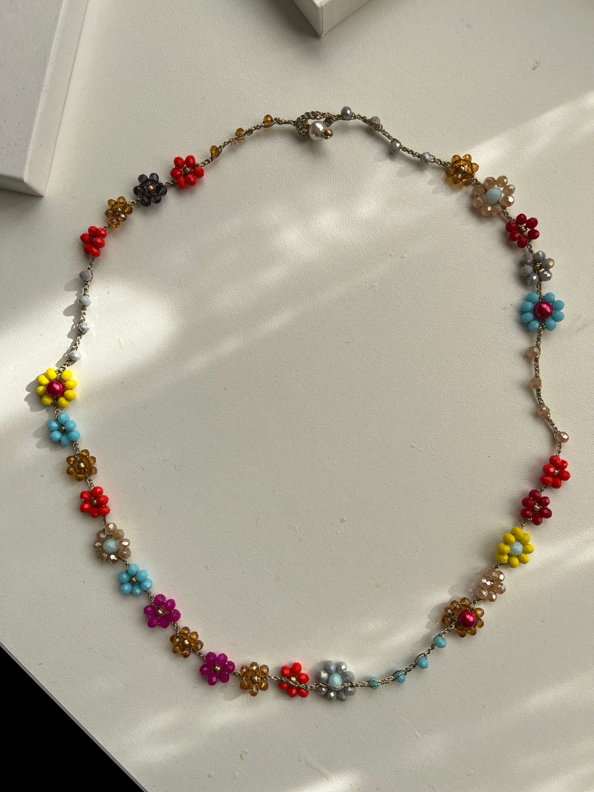Collana-bracciale Primavera Improvvisa: accessorio uncinetto con decorazioni floreali. Pezzo unico artigianale multiuso in stile primavera