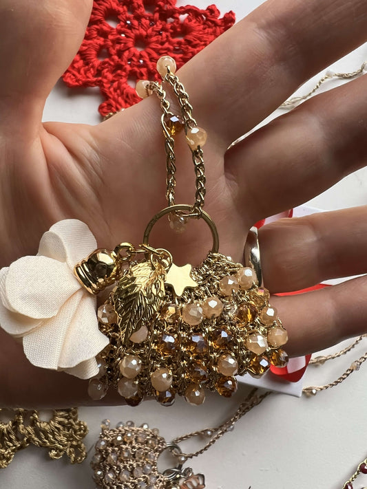 Se cerchi un regalo di Natale per una donna sofisticata, le MiniBAG con ciondolo Borsetta in bianco, beige e oro sono il dettaglio unico che conquista.