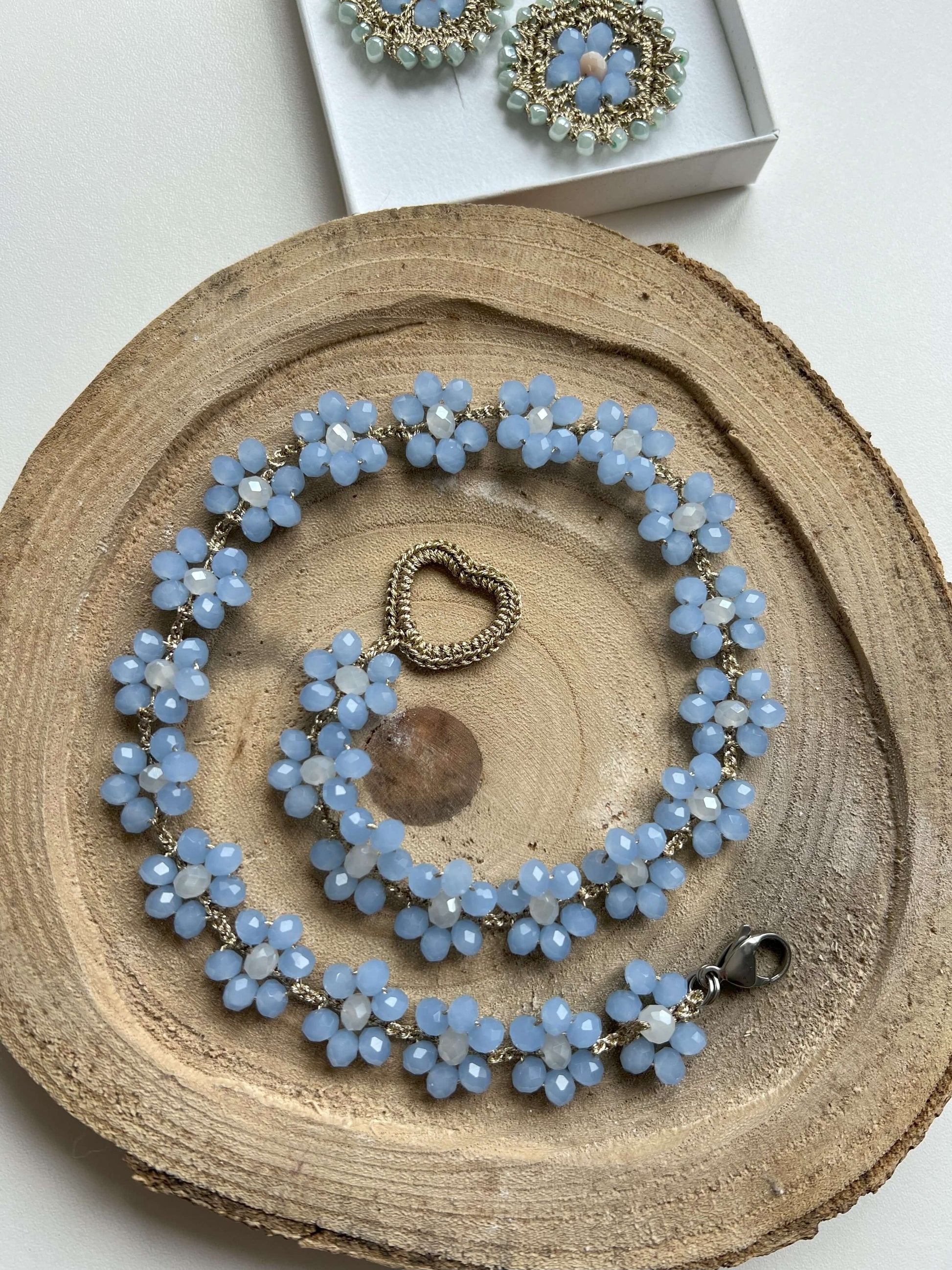Scopri la nostra esclusiva collana Fiori Azzurro Polvere, realizzata a mano con cura artigianale. Ogni fiore è unico, conferendo al tuo look un'eleganza floreale senza tempo. Acquista ora e aggiungi un tocco di originalità al tuo stile!