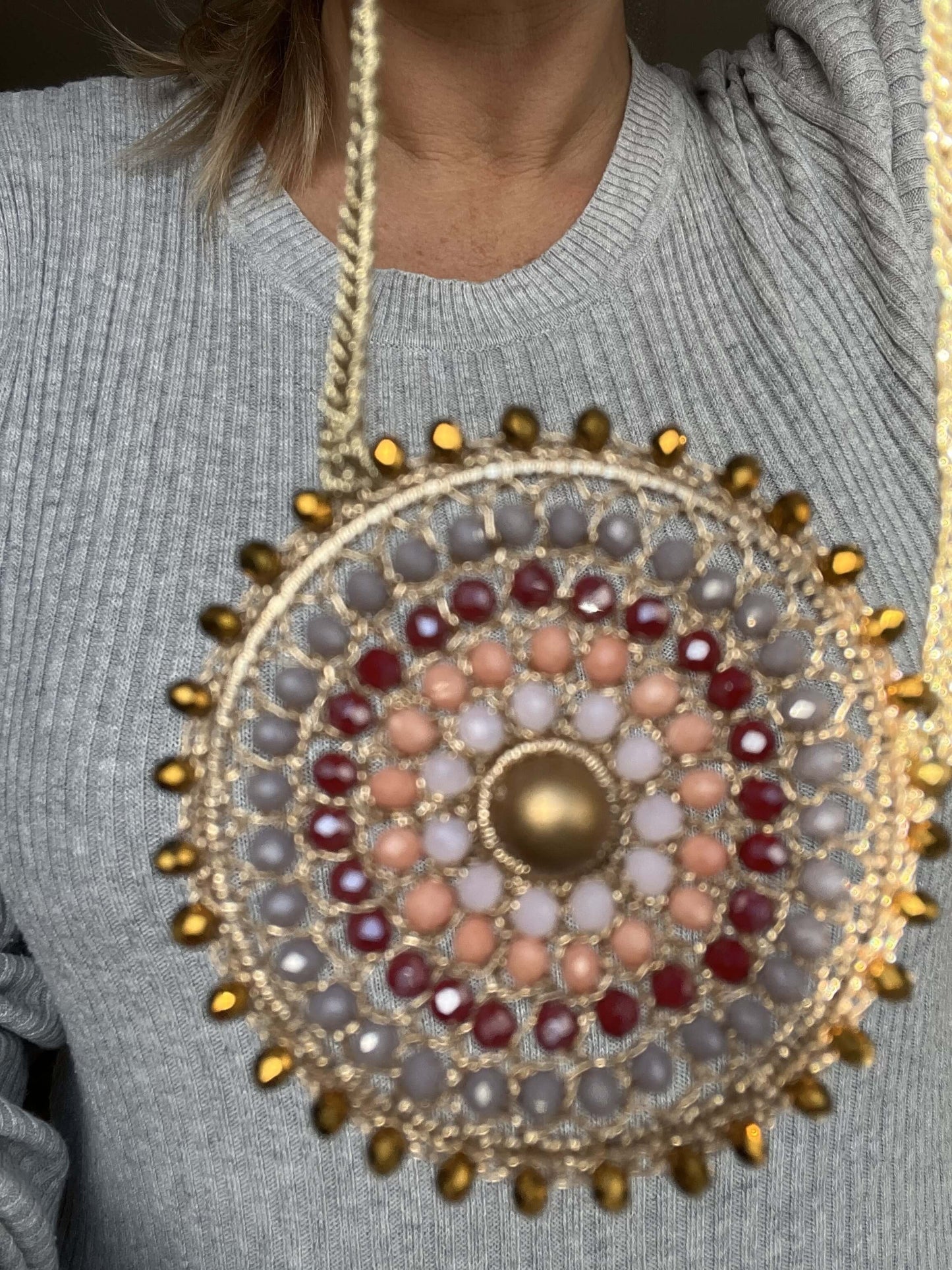 Porta luce e colore ogni giorno con questa collana mandala unica, con perla dorata e cristalli che illuminano il tuo stile.