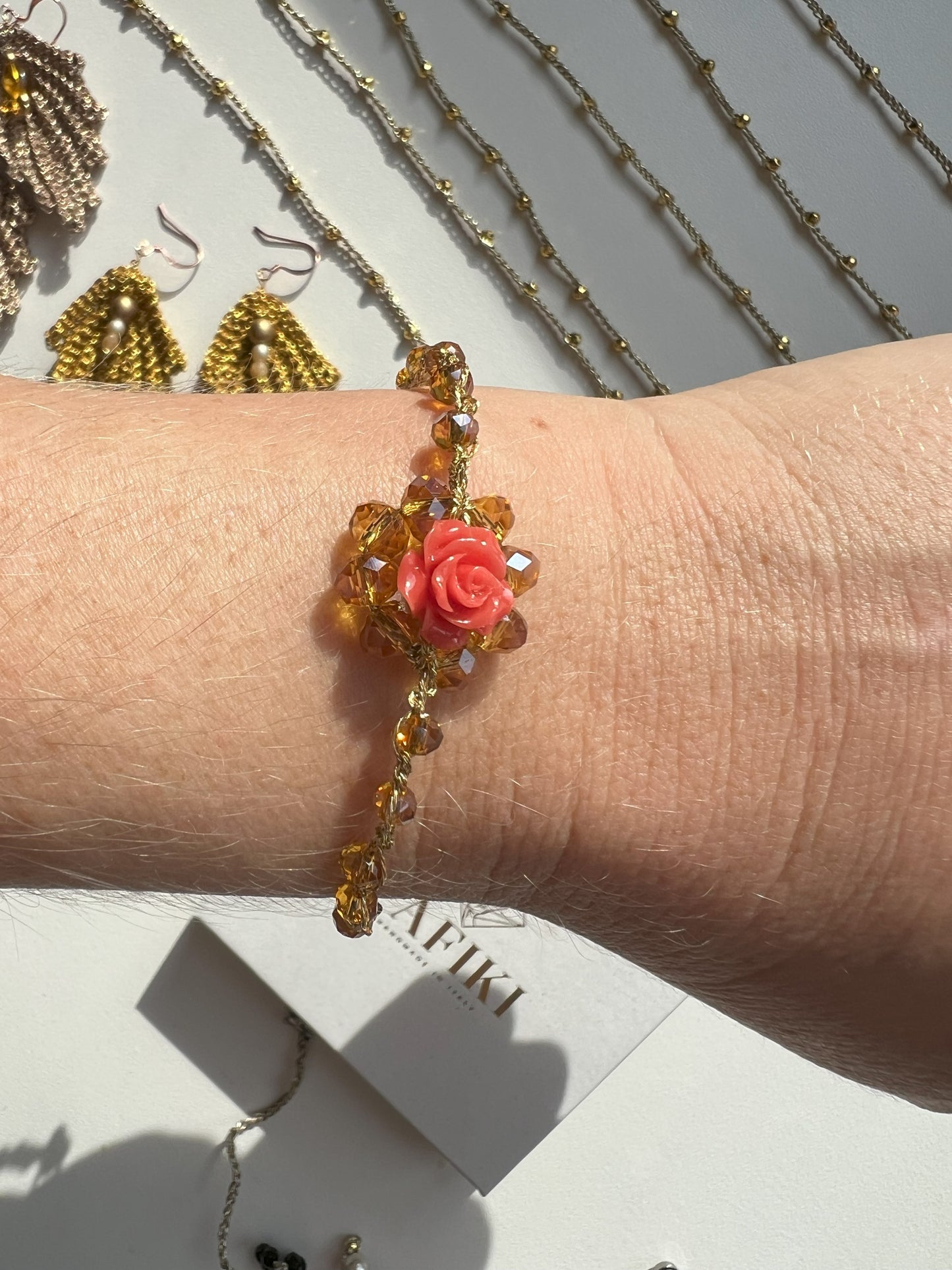 Bracciale elegante regolabile artigianale con cristalli rosa e corallo centrale, perfetto per uno stile raffinato e naturale. Fatto a mano con cura
