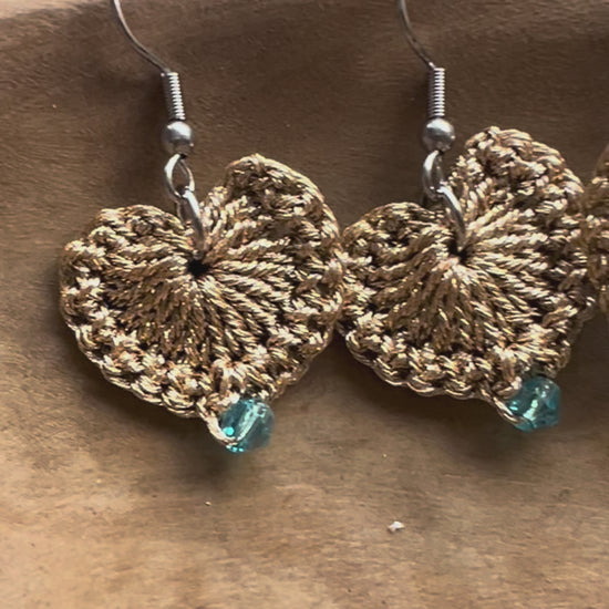 Delicate handmade heart earrings with a touch of gold and a blue crystal at the center