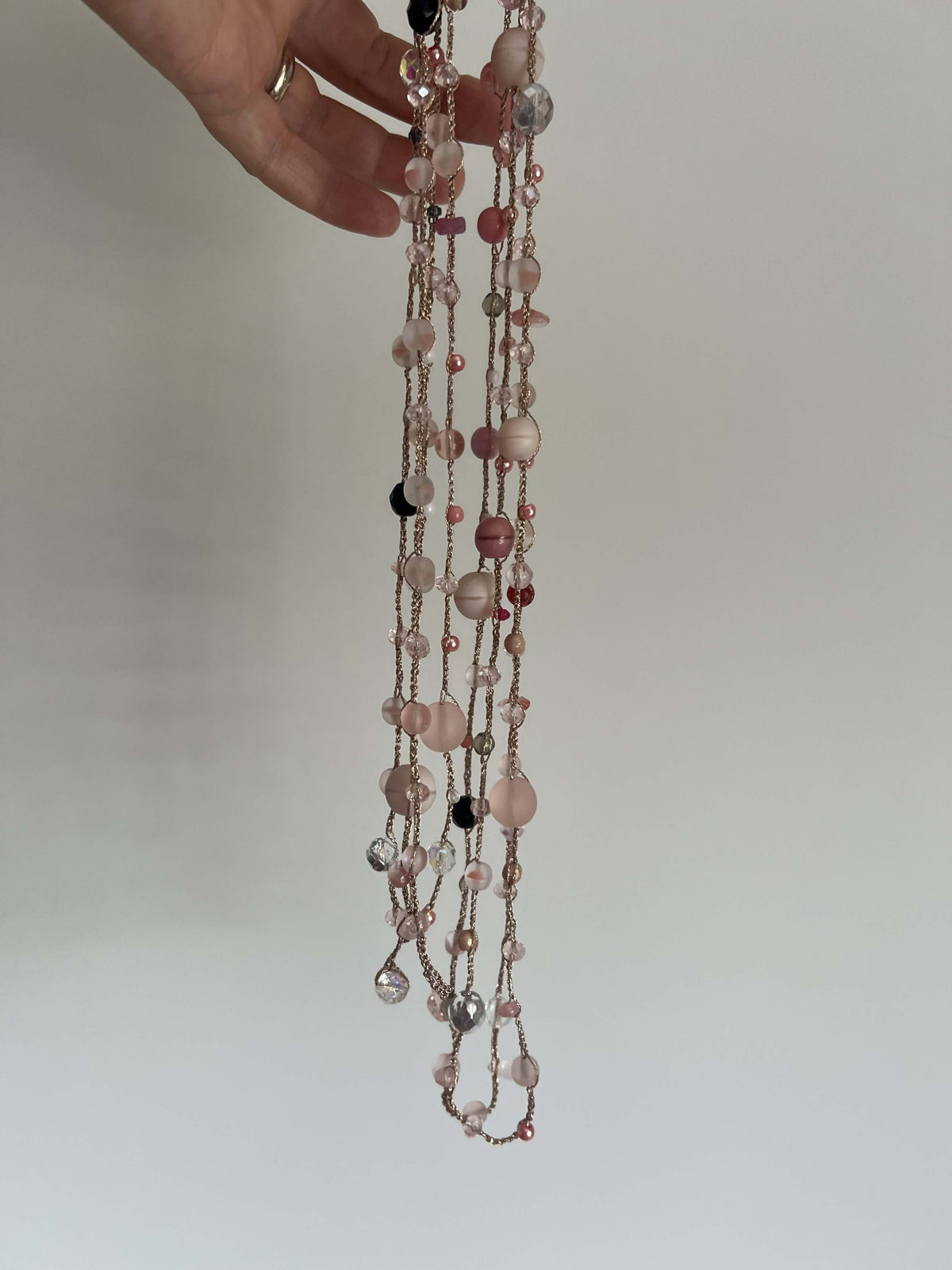 Gioiello unico nei toni del rosa cipria, lungo e avvolgente, pensato per completare con eleganza ogni outfit.