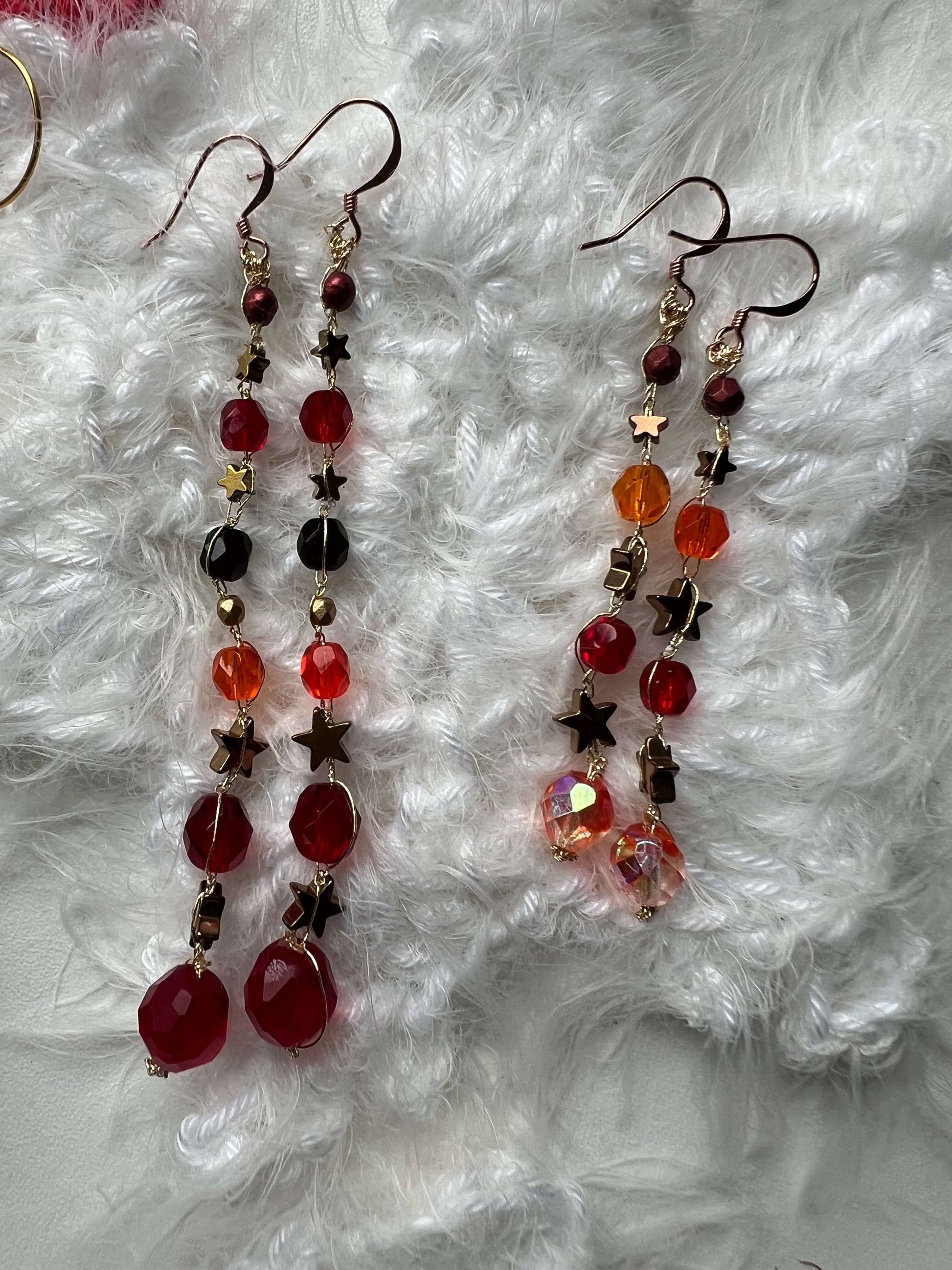 Orecchini stelle rosse e arancio fatti a mano con ematite e perle di vetro. Luminosi, originali, perfetti come regalo unico.