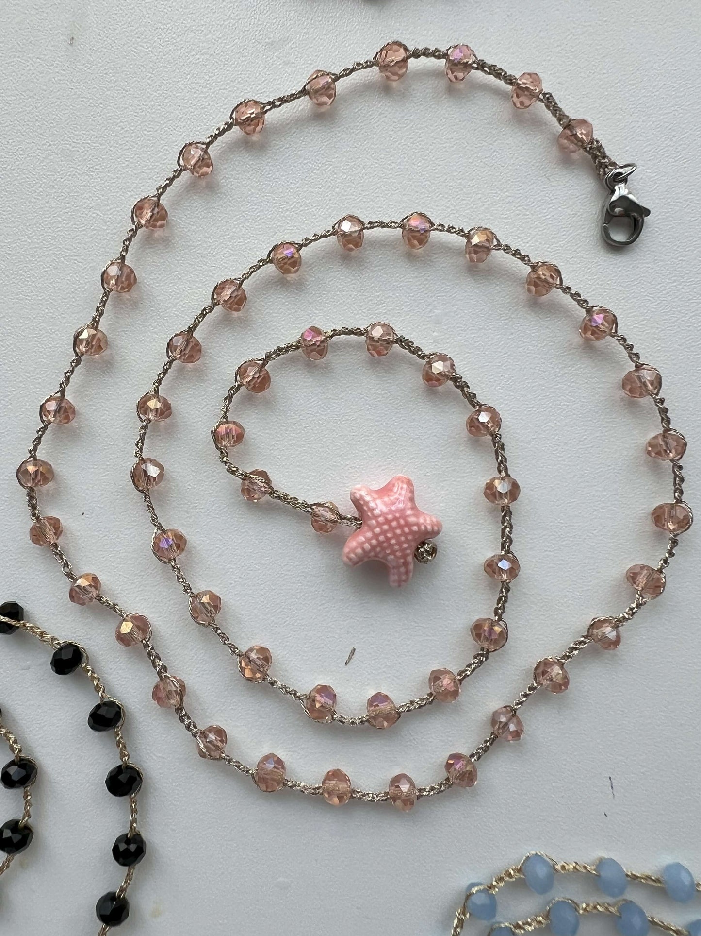 Collana boho rosa trasparente con stella in ceramica e cristalli in crochet