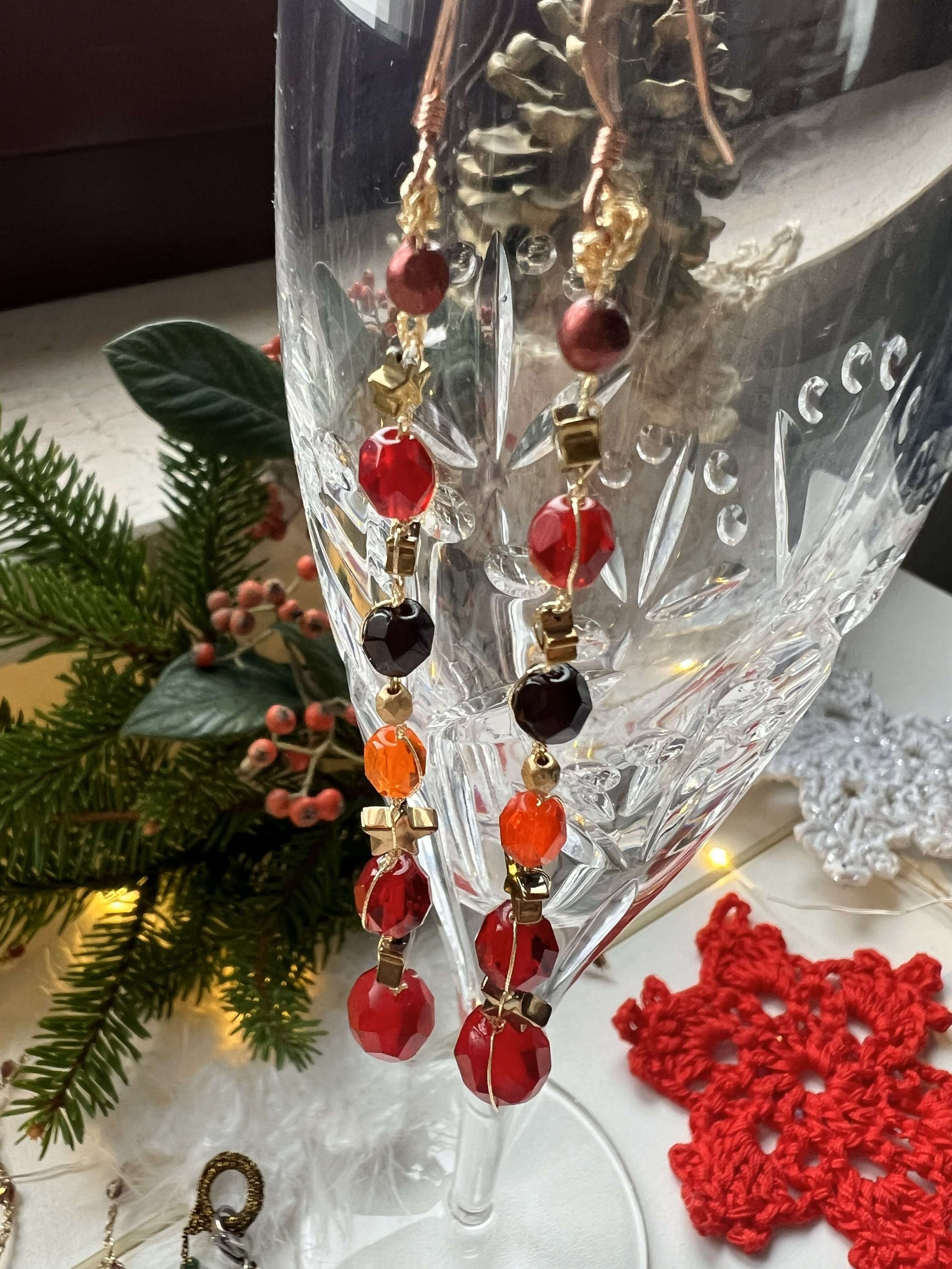 Orecchini rossi fatti a mano con stelle e perle di vetro. Caldi, brillanti e versatili: ideali per chi ama accessori luminosi.