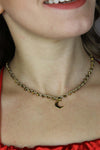 Girocollo artigianale Fafiki in color oro, realizzato con cristalli dorati e pietre di ematite color oro. Caratterizzato da una delicata luna in acciaio inossidabile, questo gioiello lungo 42 cm è dotato di chiusura a moschettone in acciaio galvanizzato. Perfetto per chi cerca un accessorio elegante e versatile, questo girocollo aggiunge un tocco di stile unico a ogni outfit, rendendolo un regalo ideale per le occasioni speciali.